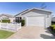 Gray house with white picket fence and attached garage at 1639 Campos Dr, The Villages, FL 32162