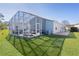 Exterior view of house with screened patio and lawn at 1639 Campos Dr, The Villages, FL 32162