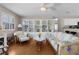 Bright living room features hardwood floors, a ceiling fan, built-in shelving, and comfortable seating at 1639 Campos Dr, The Villages, FL 32162