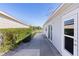 Home with side patio, hedges, and grassy yard. Access from back door at 1639 Campos Dr, The Villages, FL 32162