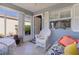 Cozy sunroom features lots of natural light, a white rocking chair and a cushioned daybed at 1639 Campos Dr, The Villages, FL 32162