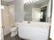 Bright bathroom with a white vanity, large mirror, and a shower-tub combo at 1897 Caryle Ln, The Villages, FL 32162