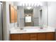 Bathroom featuring a double vanity, large mirror, and wood cabinets, creating a functional and stylish space at 1897 Caryle Ln, The Villages, FL 32162
