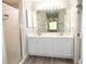 Bathroom featuring double sink vanity, white cabinets, and shower with glass door at 1897 Caryle Ln, The Villages, FL 32162