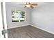 Bedroom featuring a ceiling fan, window and gray tone vinyl flooring at 1897 Caryle Ln, The Villages, FL 32162