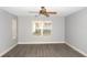 Cozy bedroom with ceiling fan, window view, and stylish gray floors at 1897 Caryle Ln, The Villages, FL 32162