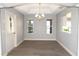 Well-lit dining room includes modern lighting, tray ceiling, and neutral color palette at 1897 Caryle Ln, The Villages, FL 32162