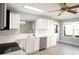 Bright kitchen features white cabinets, stainless steel appliances, and updated countertop and sink at 1897 Caryle Ln, The Villages, FL 32162