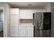 Bright kitchen with white cabinets and stainless steel refrigerator at 1897 Caryle Ln, The Villages, FL 32162