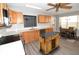 Bright kitchen features wood cabinets, stainless steel appliances, kitchen island, and adjacent dining area at 1897 Caryle Ln, The Villages, FL 32162