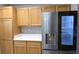 Kitchen featuring wood cabinetry, stainless steel refrigerator with ice maker, and white countertops at 1897 Caryle Ln, The Villages, FL 32162
