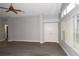 Bright living room featuring gray flooring, double-door closet, and large windows at 1897 Caryle Ln, The Villages, FL 32162
