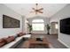 Bright living room featuring vaulted ceiling, ceiling fan, stylish gray flooring, and decorative plants at 1897 Caryle Ln, The Villages, FL 32162