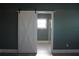 Modern bathroom featuring a stylish sliding barn door, marble floors, and a glass-enclosed shower at 2437 Bay Lake Loop, Groveland, FL 34736