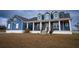 Charming blue two-story home featuring a welcoming front porch with stylish columns and a landscaped front yard at 2437 Bay Lake Loop, Groveland, FL 34736