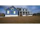 Inviting blue two-story home featuring a charming front porch and well-manicured lawn at 2437 Bay Lake Loop, Groveland, FL 34736