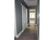 Hallway with a white barn door and wood-look floors leading to a sunlit room at 2437 Bay Lake Loop, Groveland, FL 34736