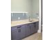 Well-lit laundry room with grey cabinetry, granite countertops, and a stainless steel sink at 2437 Bay Lake Loop, Groveland, FL 34736