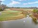Aerial view of a golf course with pond and a bird in flight at 3606 Adamsville Ave, The Villages, FL 32163