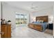 Main bedroom with king-size bed, wood dresser, and sliding glass doors to a patio at 3606 Adamsville Ave, The Villages, FL 32163