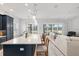 Open kitchen features a large island with seating, white cabinets, and modern pendant lighting at 3606 Adamsville Ave, The Villages, FL 32163