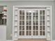 White French doors with glass panes, opening to a sunroom, and built-in shelves at 8850 Sw 97Th St # E, Ocala, FL 34481