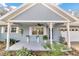 Inviting front porch with hanging plants and classic columns at 8850 Sw 97Th St # E, Ocala, FL 34481