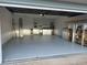 Spacious garage with painted floor, utility area, and storage shelving at 8850 Sw 97Th St # E, Ocala, FL 34481