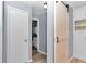 Hallway with wood-look floors, barn door, and access to bathroom at 8850 Sw 97Th St # E, Ocala, FL 34481