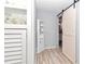 Hallway with wood-look floors, sliding barn door, and built-in shelving at 8850 Sw 97Th St # E, Ocala, FL 34481