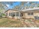 Rear view of a light yellow house with a screened porch and a grassy yard at 8850 Sw 97Th St # E, Ocala, FL 34481