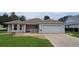 Charming single-story home with well-manicured lawn, rock landscaping, and attached two car garage at 9199 Se 171St Cooper Loop, The Villages, FL 32162