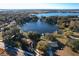 Aerial view of a waterfront community surrounded by mature trees and a large body of water at 9835 Lakeshore Dr, Clermont, FL 34711