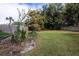 Grassy backyard with mature trees and partial fencing at 1001 Michelle Ct, Tavares, FL 32778