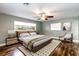 Cozy bedroom featuring wood floors, a ceiling fan, and ample natural light from the windows at 1001 Michelle Ct, Tavares, FL 32778