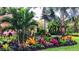 Lush, tropical landscaping with vibrant bromeliads and palm trees surrounding the property at 1001 Michelle Ct, Tavares, FL 32778