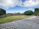 Spacious backyard with a paver patio, lush lawn, mature trees, and a picturesque wooden fence at 1320 Arredondo Dr, The Villages, FL 32162