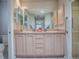 Well-lit bathroom featuring double sinks, ample cabinet space, a large mirror, and a glass-enclosed shower at 1320 Arredondo Dr, The Villages, FL 32162
