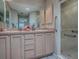 Well-lit bathroom featuring double sinks, ample cabinet space, a large mirror, and a glass-enclosed shower at 1320 Arredondo Dr, The Villages, FL 32162