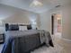 Cozy bedroom with ceiling fan, a large bed, and bathroom access, creating a comfortable and inviting retreat at 1320 Arredondo Dr, The Villages, FL 32162