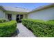 Inviting front entrance with a paved walkway, manicured hedges, and a charming seating area at 1320 Arredondo Dr, The Villages, FL 32162