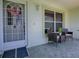 Inviting front porch with tiled flooring, seating, and decorative wreath on door at 1320 Arredondo Dr, The Villages, FL 32162