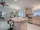 Open kitchen featuring island with seating and stainless steel appliances; open to living area at 1320 Arredondo Dr, The Villages, FL 32162