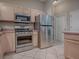 Contemporary kitchen featuring stainless steel appliances and bright, wooden cabinetry at 1320 Arredondo Dr, The Villages, FL 32162