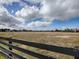 Vast parcel of land beyond a wooden fence, offering scenic views and potential for future development at 1320 Arredondo Dr, The Villages, FL 32162