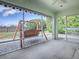 Charming screened patio showcases a wooden swing set with views of the lush backyard and a rustic fence at 1320 Arredondo Dr, The Villages, FL 32162