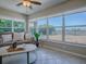 Inviting sunroom featuring tile floor, ceiling fan, large windows with a peaceful outdoor view, and cozy seating at 1320 Arredondo Dr, The Villages, FL 32162