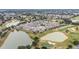 Expansive aerial view of a community nestled between serene ponds and a lush golf course, showcasing a peaceful living environment at 17159 Se 78Th Crowfield Ave, The Villages, FL 32162