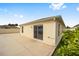 The back of the house features a sliding glass door and windows overlooking the concrete patio at 17159 Se 78Th Crowfield Ave, The Villages, FL 32162