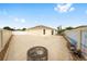 The backyard of this home includes a concrete patio with a fire pit and colorful painted fence at 17159 Se 78Th Crowfield Ave, The Villages, FL 32162